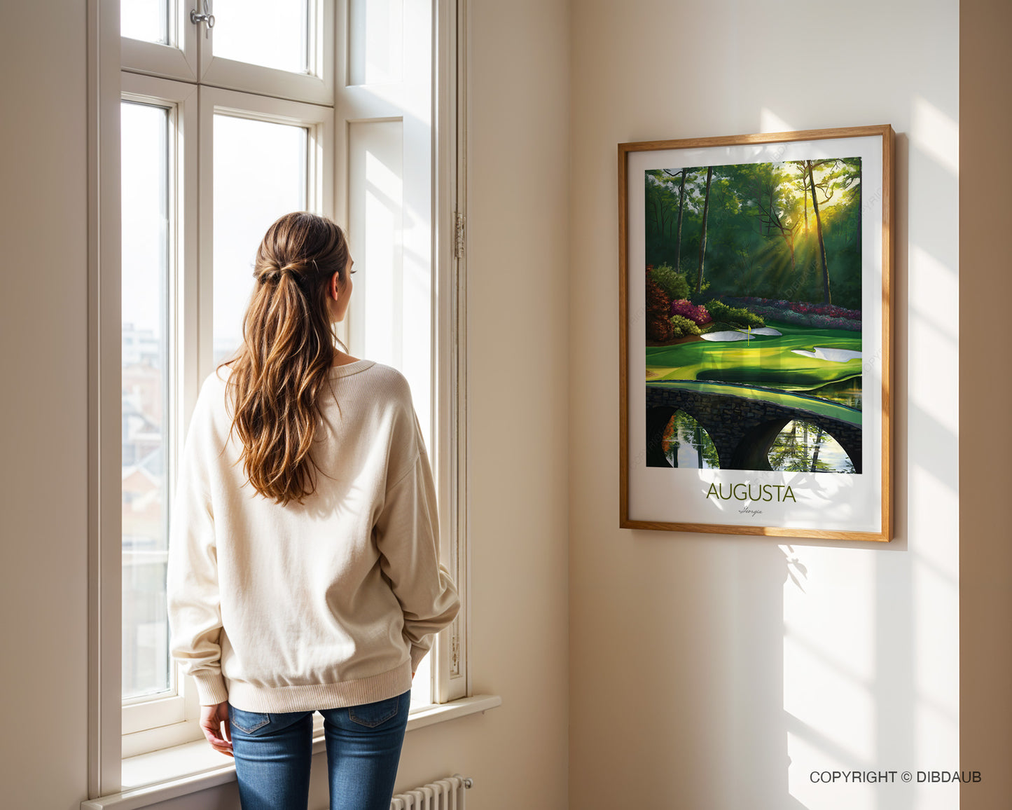 Woman standing by a window looking at a framed painting of Augusta National Golf Course.