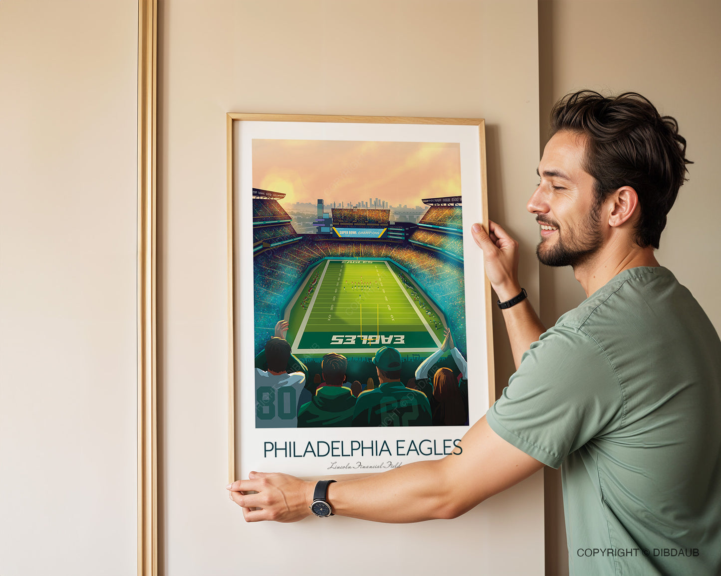 Man hanging a framed Philadelphia Eagles poster on a wall.