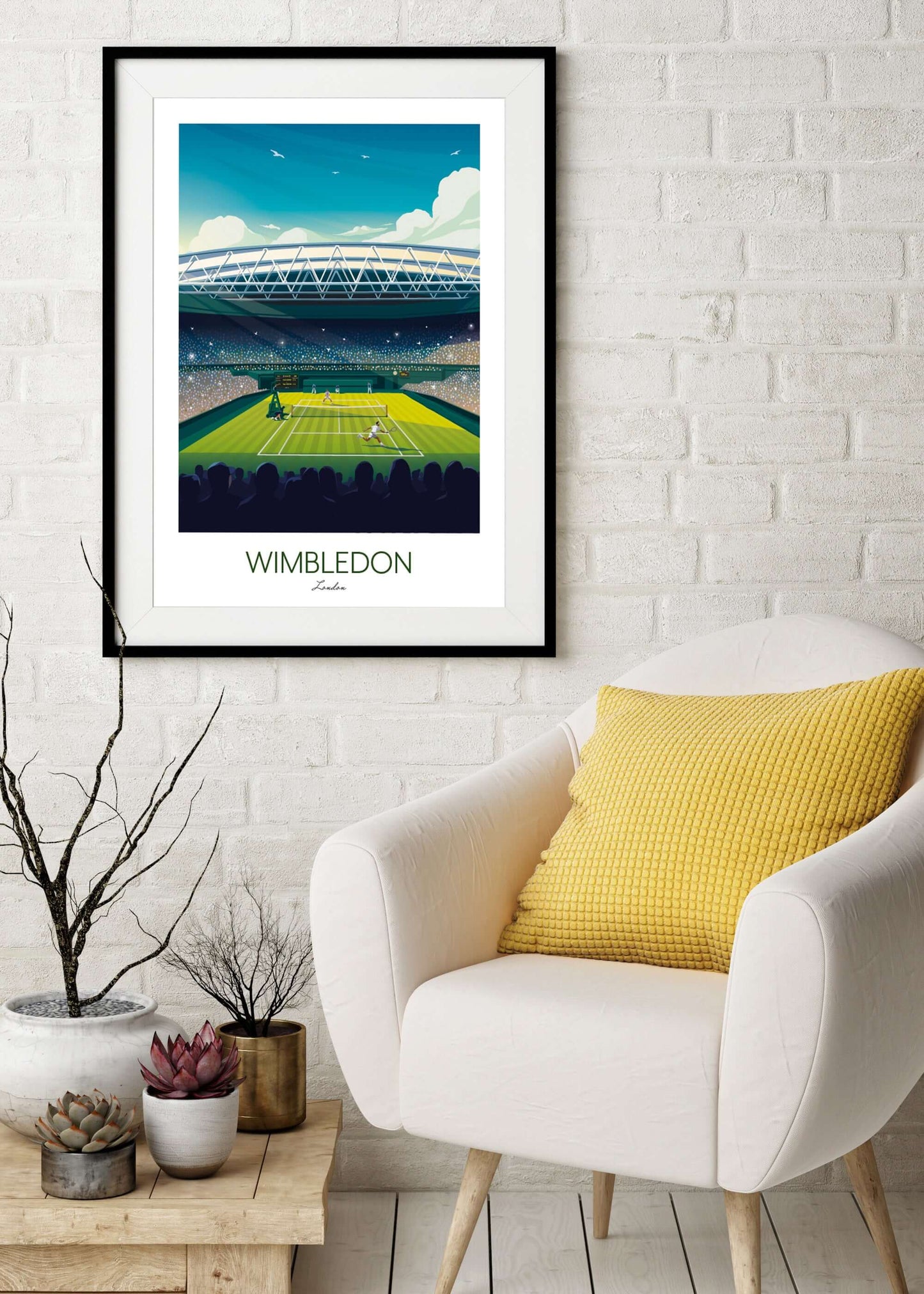 Framed wall art poster of Wimbledon, placed on a wall above a cream armchair and plant.