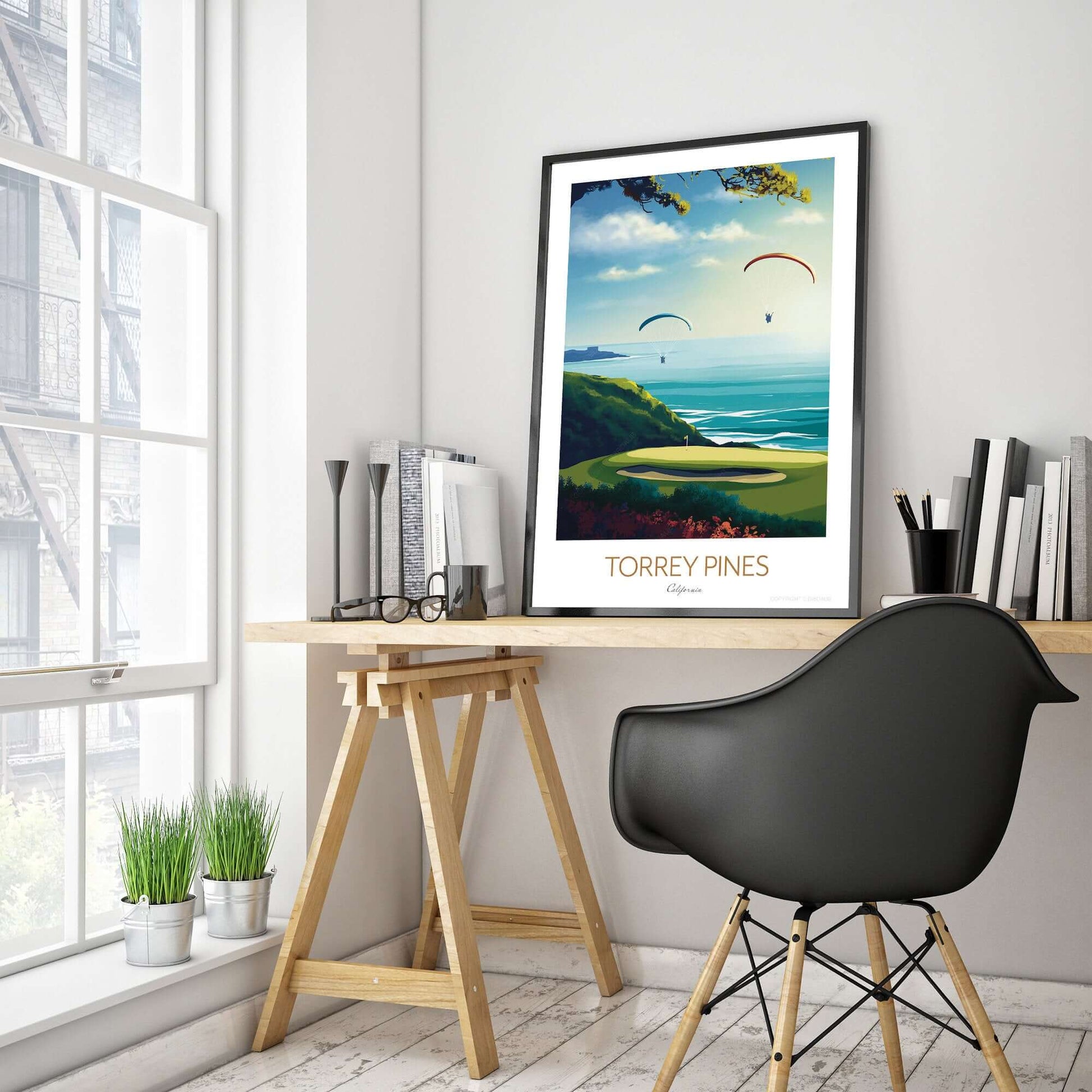 A golf course print of Torrey Pines, with a black frame placed on a office desk.
