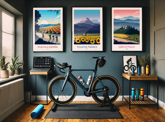 Cycling pain cave with 3 framed cycling prints on the wall above a training bicycle and gym equipment on the floor.