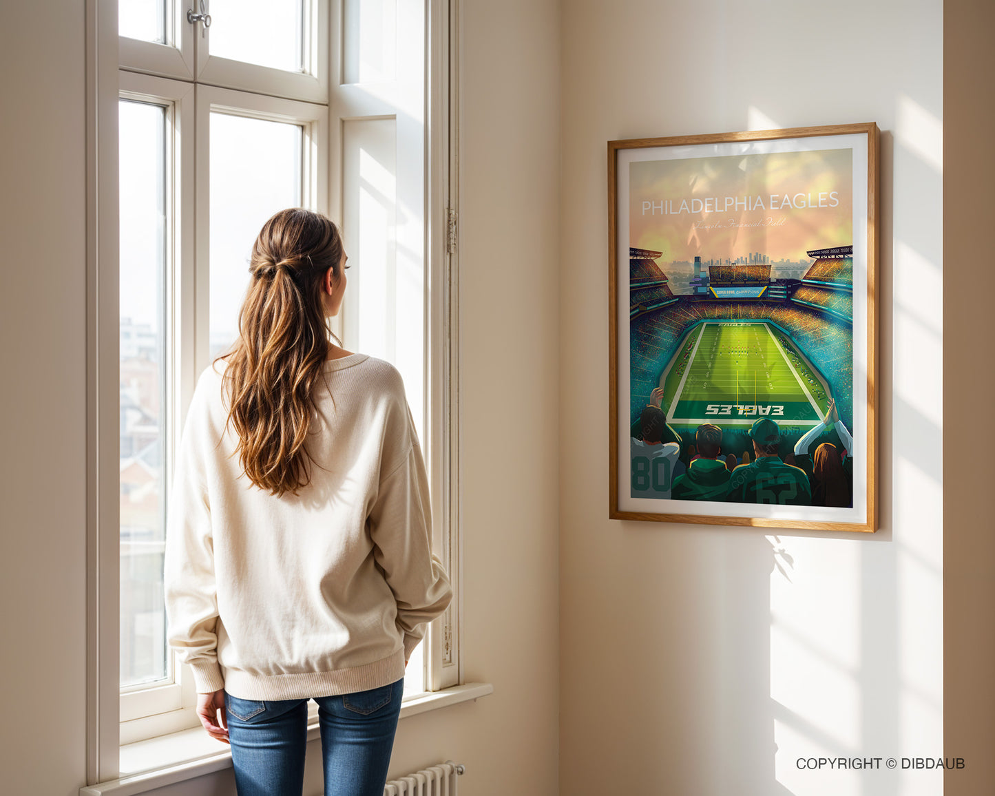 Woman standing by a window looking at a framed artwork of a Philadelphia Eagles Lincoln Financial Field stadium.