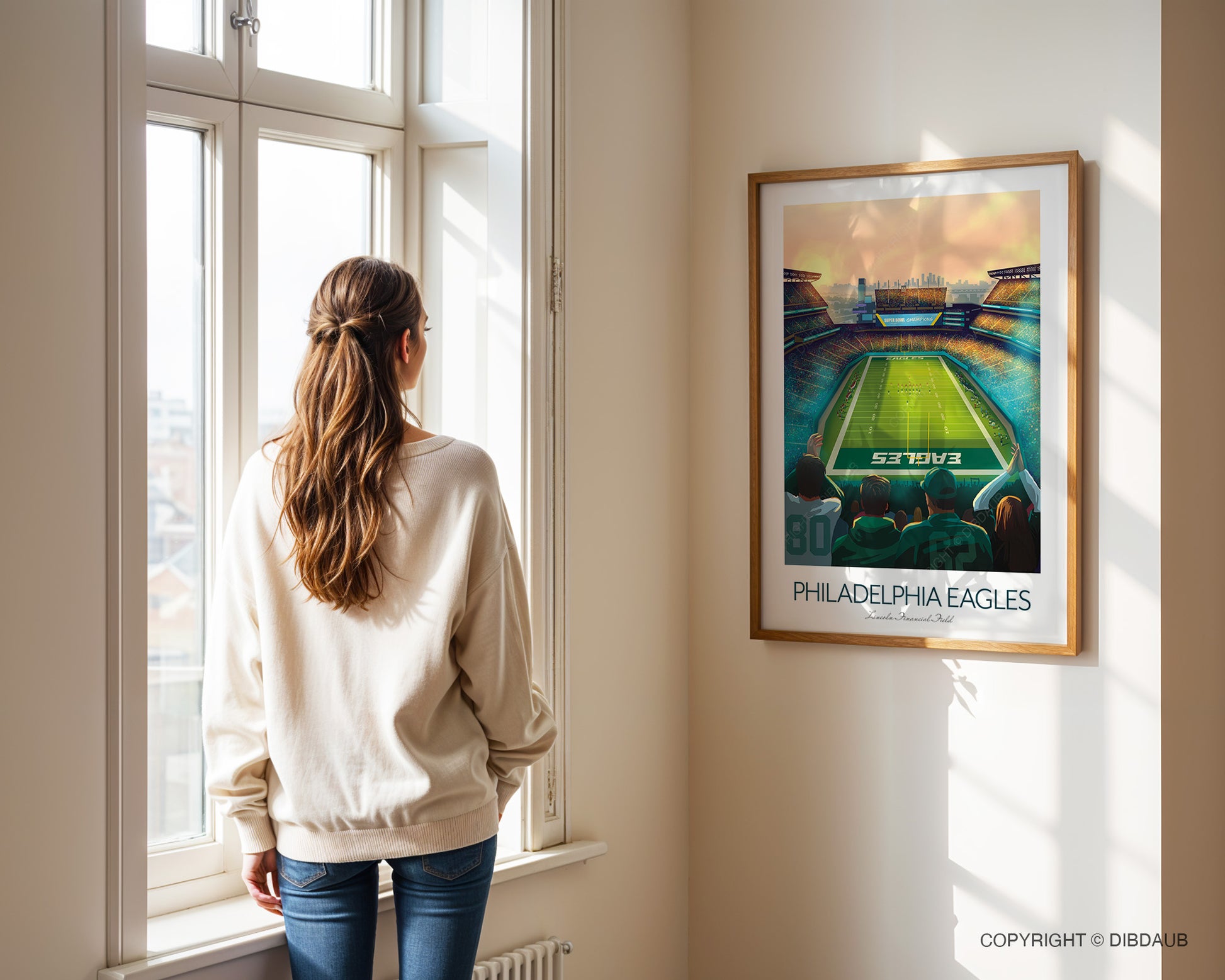 Woman standing by a window looking at a framed Philadelphia Eagles poster.