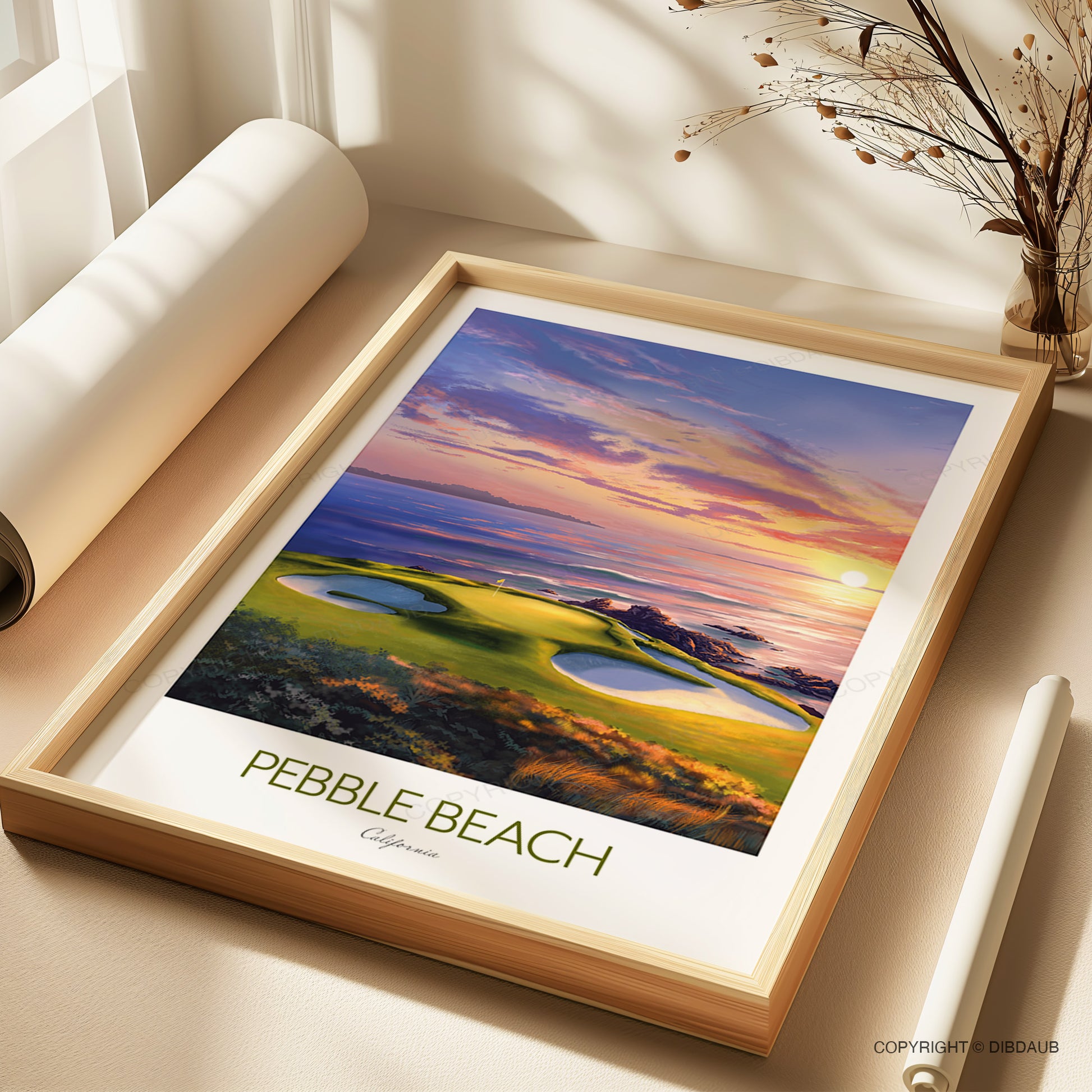 Framed fine art print of Pebble Beach golf course with a sunset, placed on a surface.