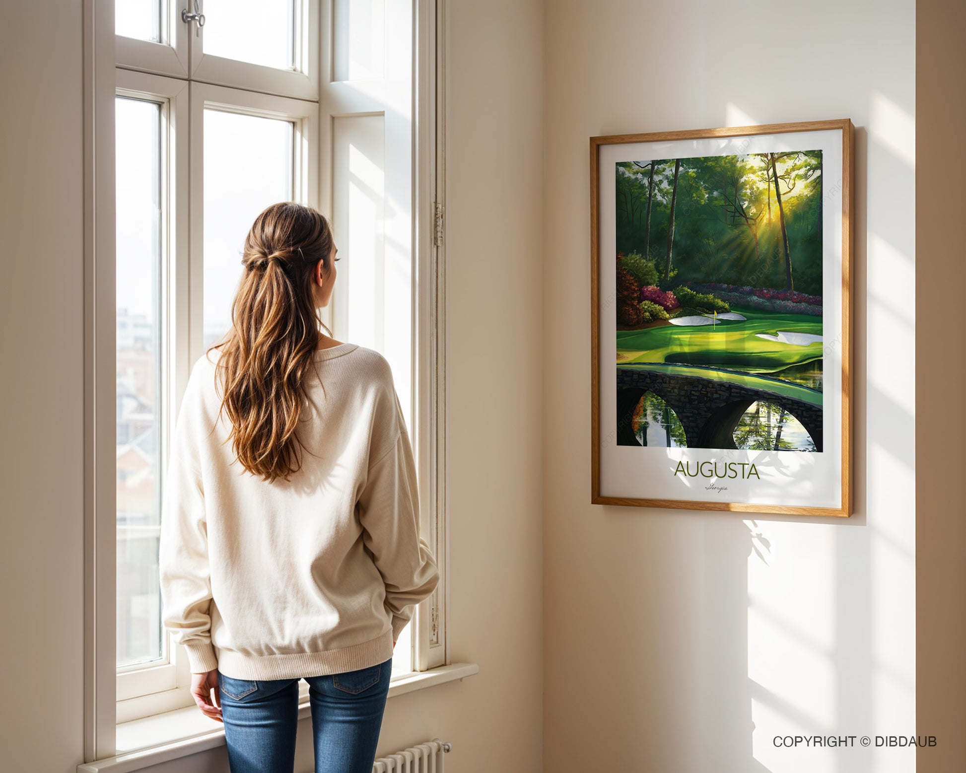 Woman standing by a window looking at a framed painting of Augusta National Golf Course.