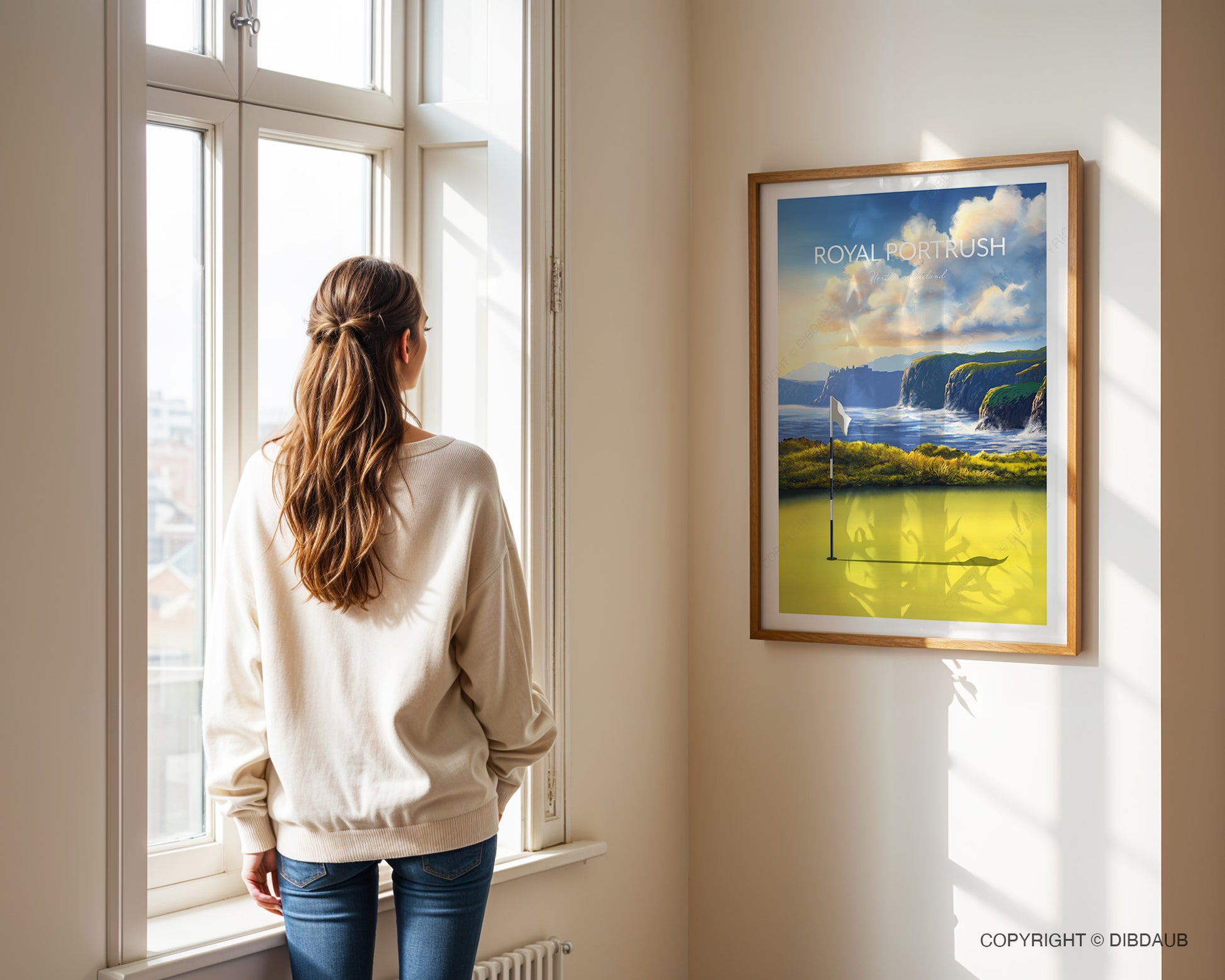 Woman standing by a window looking at a framed golf course art print of Royal Portrush.