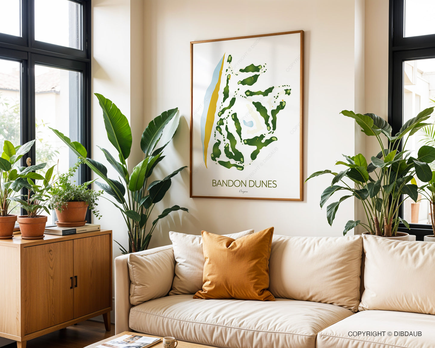 Living room with beige sofa, plants, and a framed artwork of Bandon Dunes course layout on the wall.