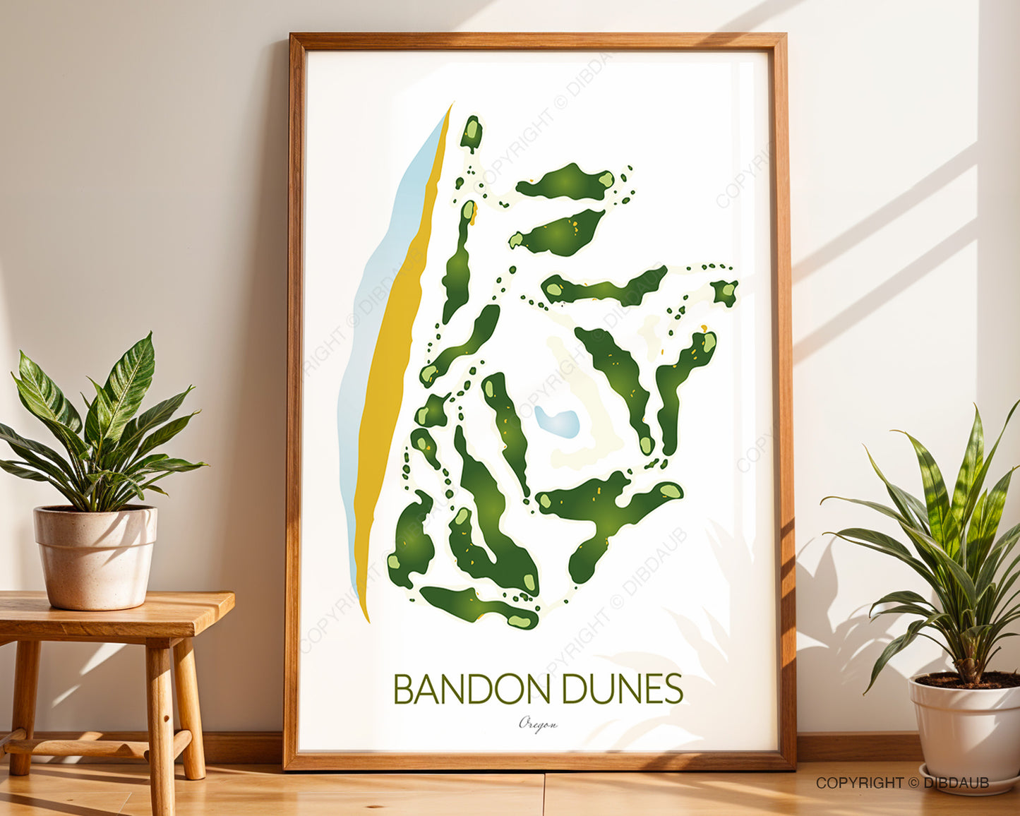 Framed artwork of Bandon Dunes golf course map on a wall with plants and a table.