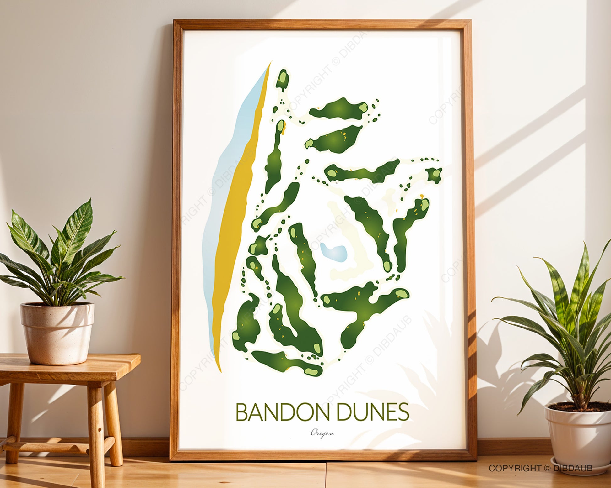 Framed artwork of Bandon Dunes golf course map on a wall with plants and a table.