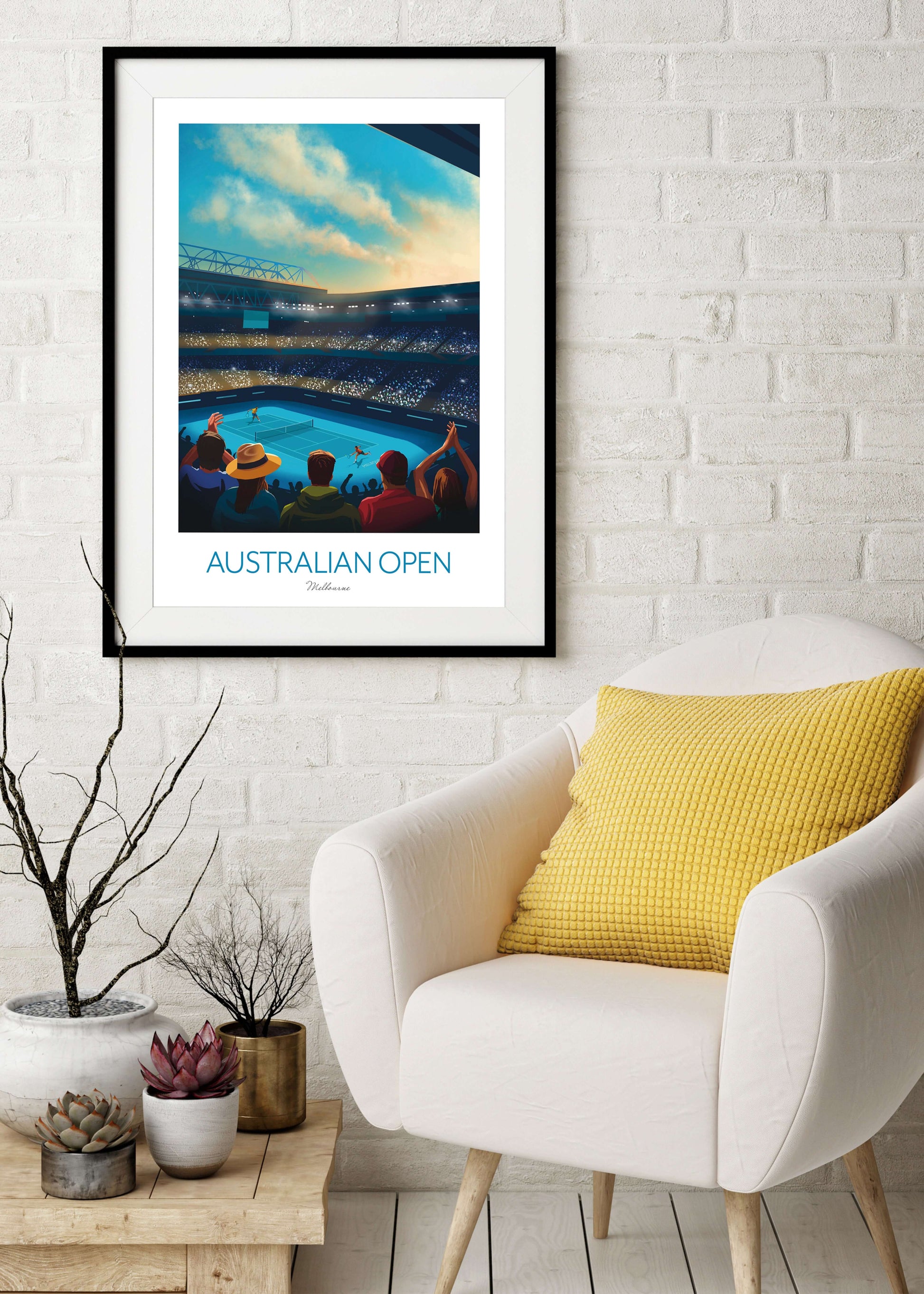 Framed tennis art print of the Australian Open, hanging on a reception room wall above a armchair. 