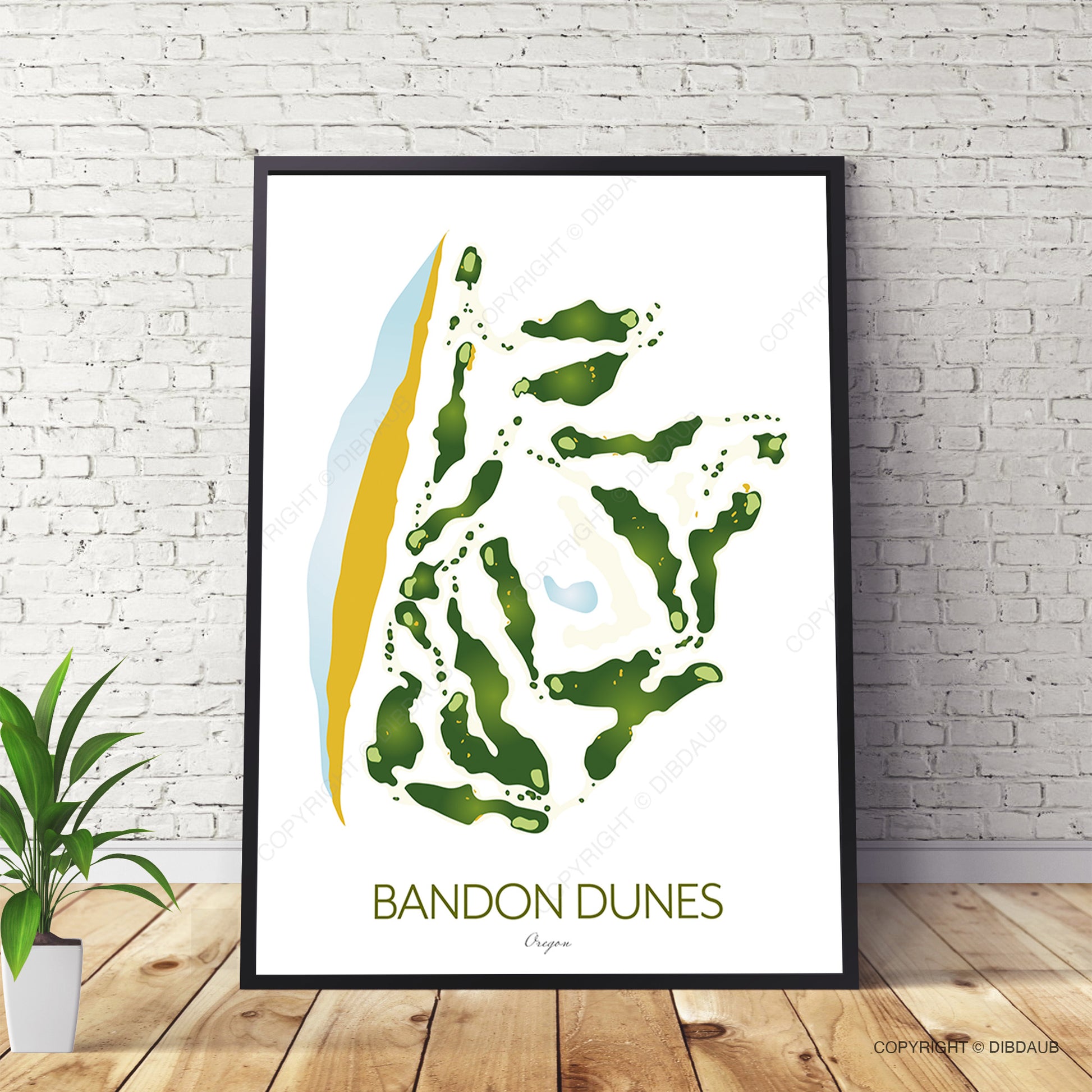 Framed artwork of Bandon Dunes golf course on a white wall with a plant and wooden floor.