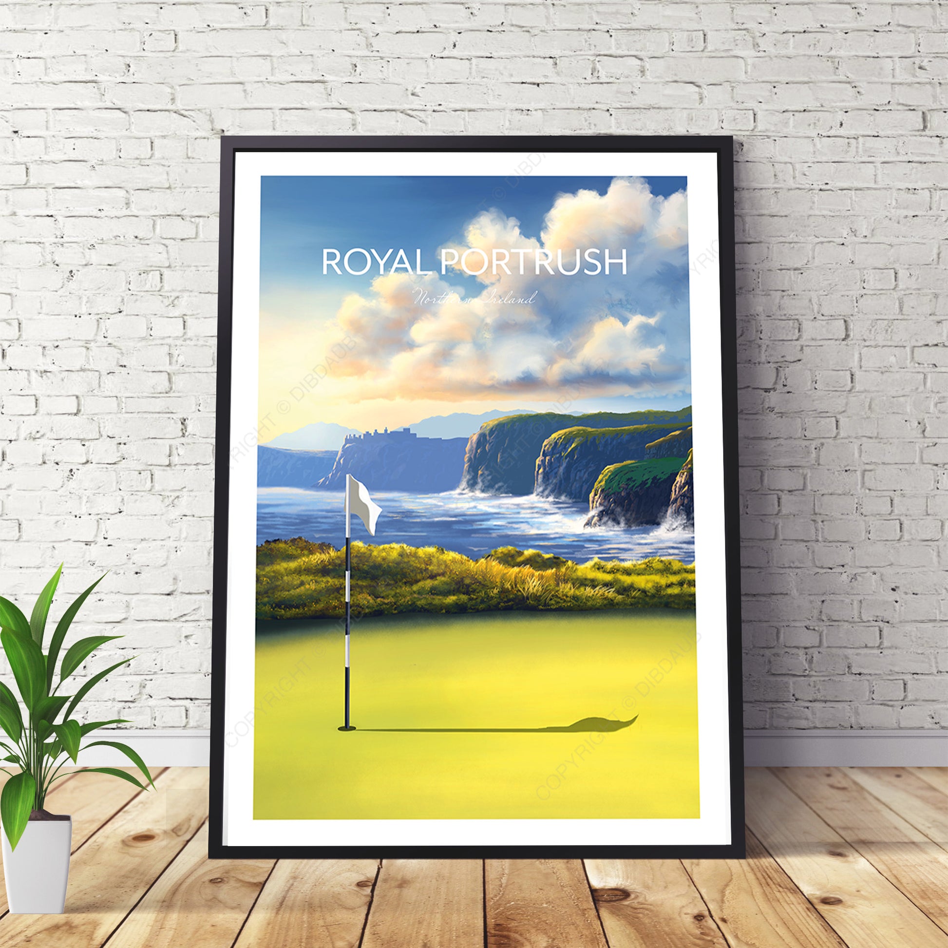 Framed artwork of a golf course with cliffs and ocean, labeled 'Royal Portrush', on a white brick wall.