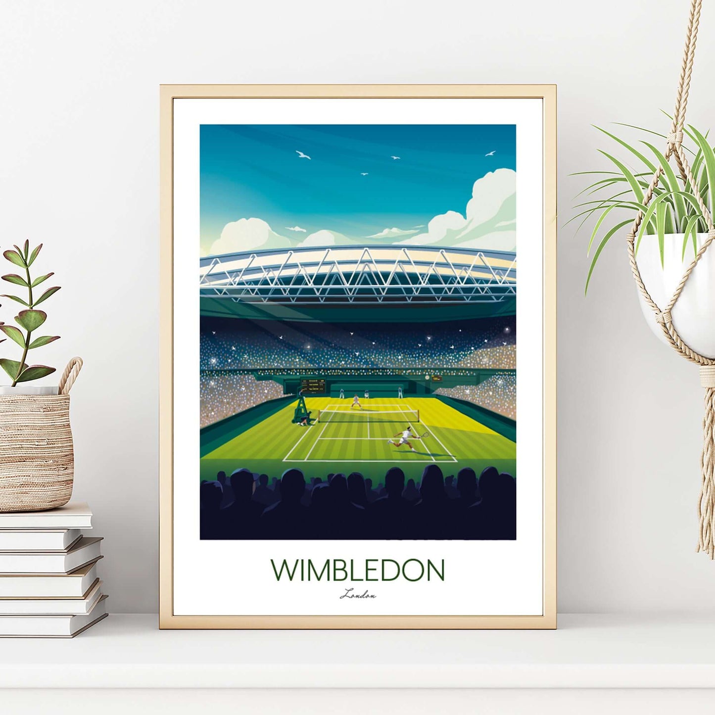 Framed poster of Wimbledon centre court in a gold frame, placed on a sideboard with plants either side.