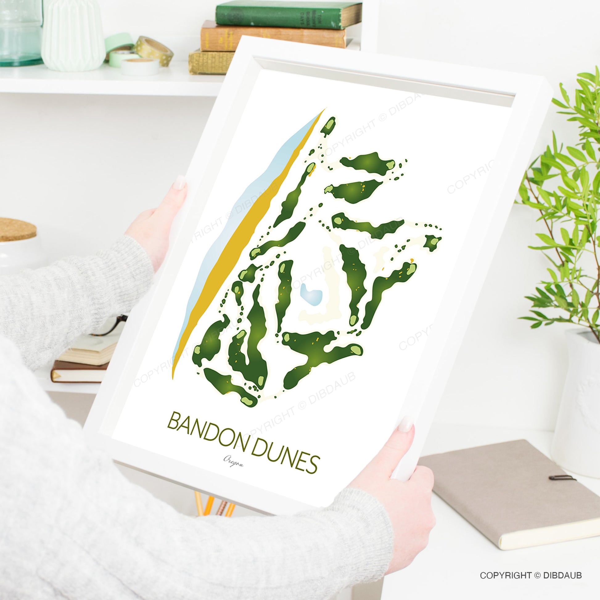 Person holding a framed print of Bandon Dunes golf course design.
