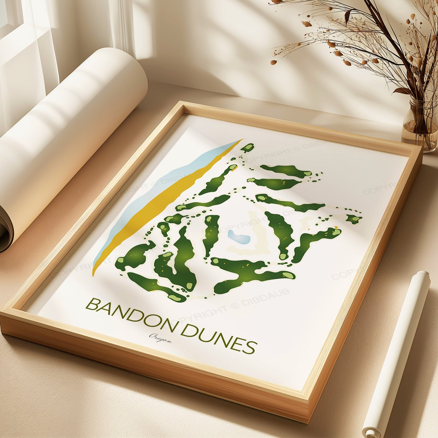 Framed artwork of Bandon Dunes golf course design on a light surface, being gift wrapped.