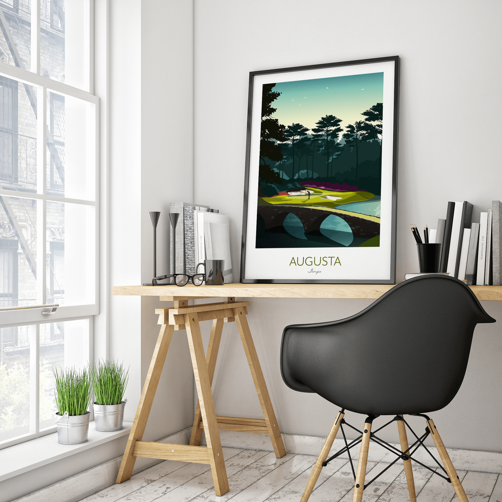 A golf print of Augusta National with a black frame and placed on a IKEA trestle desk within a home office.
